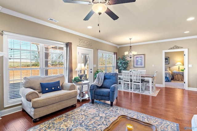 living area featuring dark wood-style floors, visible vents, ornamental molding, and baseboards