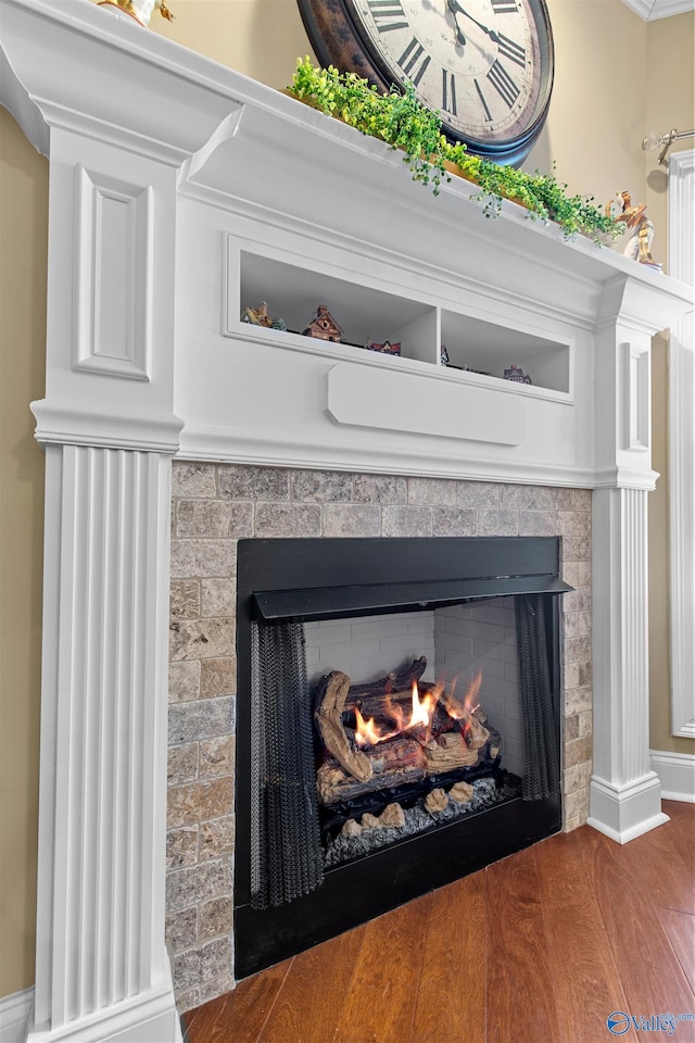 interior details with a fireplace, baseboards, and wood finished floors