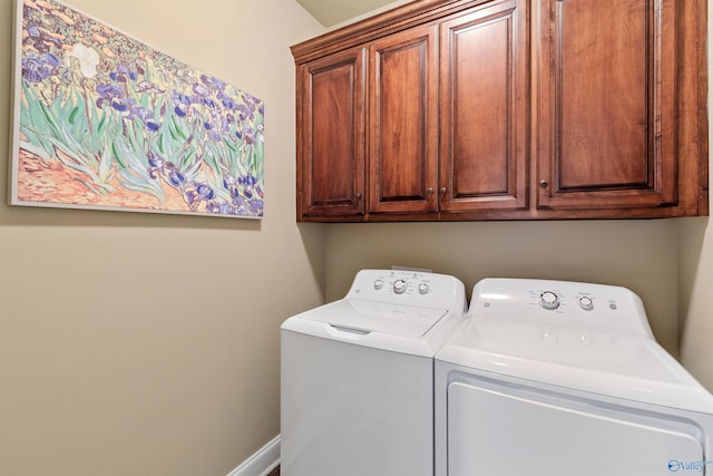 laundry room featuring baseboards, cabinet space, and washer and dryer