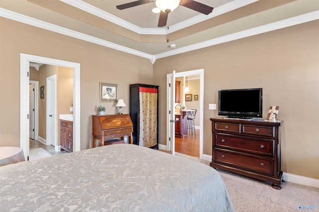 bedroom featuring baseboards, a raised ceiling, connected bathroom, light colored carpet, and ornamental molding