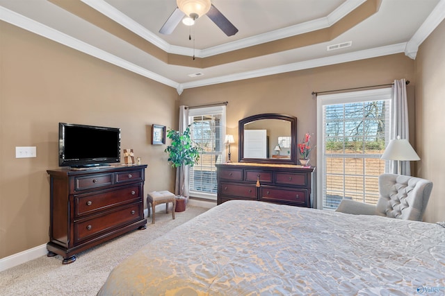 bedroom with light carpet, multiple windows, baseboards, and a raised ceiling