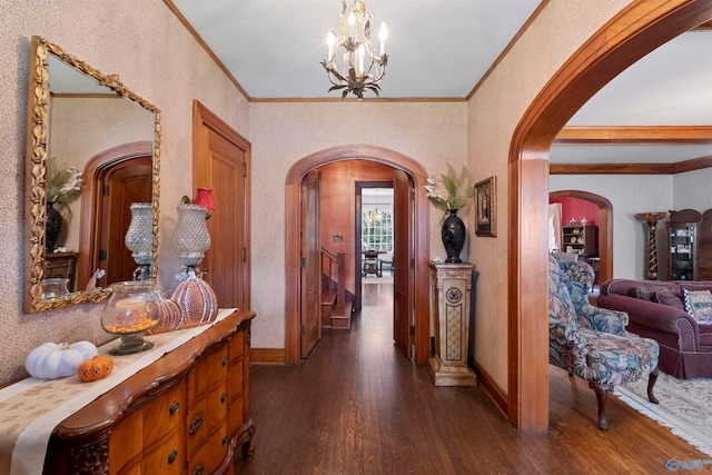 entryway featuring ornamental molding, an inviting chandelier, and dark wood-type flooring