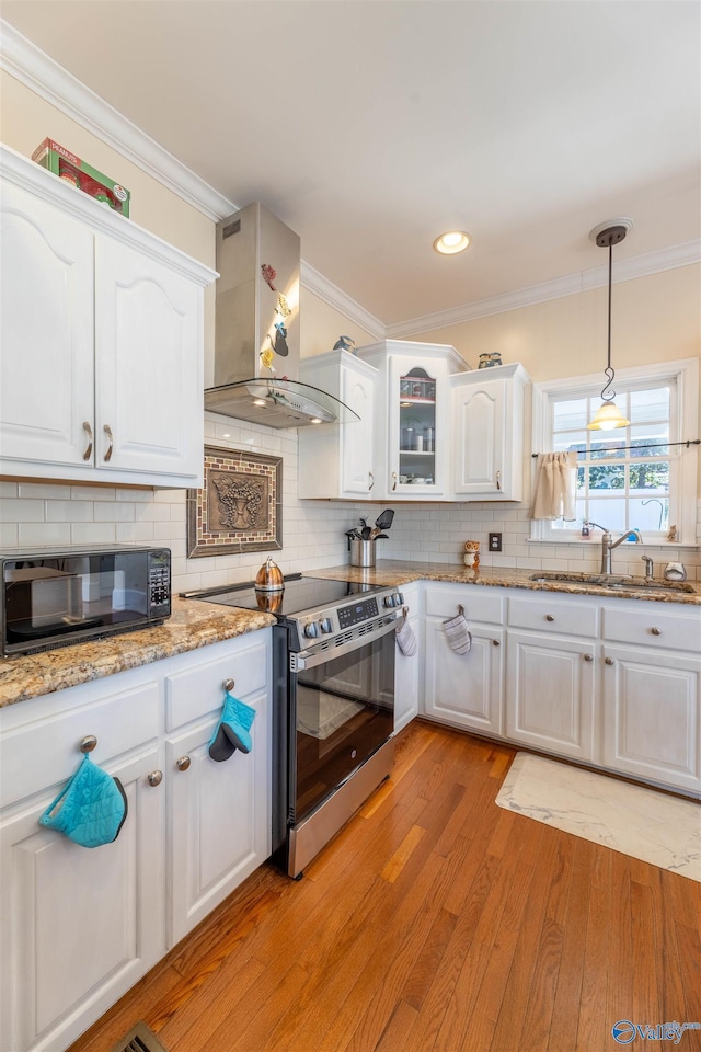 kitchen with black microwave, a sink, white cabinetry, ventilation hood, and stainless steel range with electric stovetop