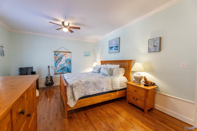 bedroom with baseboards, ornamental molding, and wood finished floors