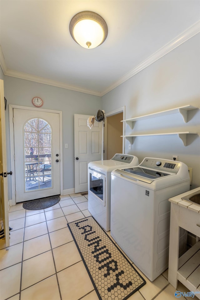 laundry area featuring light tile patterned flooring, laundry area, baseboards, ornamental molding, and washing machine and clothes dryer