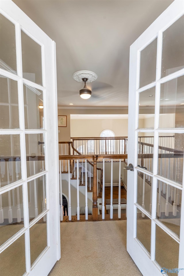 corridor with french doors, stairway, carpet flooring, and crown molding