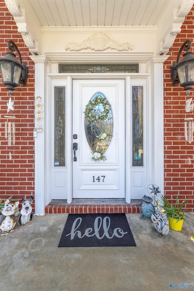 view of exterior entry featuring brick siding