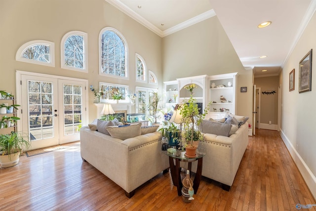 living room featuring baseboards, ornamental molding, wood finished floors, and french doors