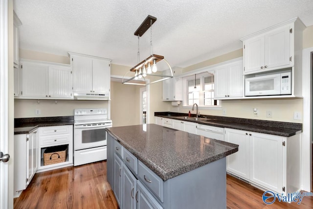 kitchen with sink, white cabinetry, a textured ceiling, a kitchen island, and white appliances