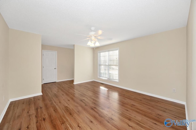 empty room with hardwood / wood-style floors, a textured ceiling, and ceiling fan