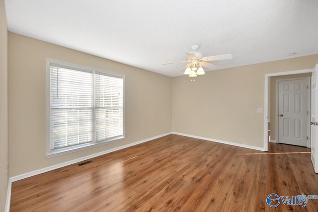 spare room with dark wood-type flooring and ceiling fan