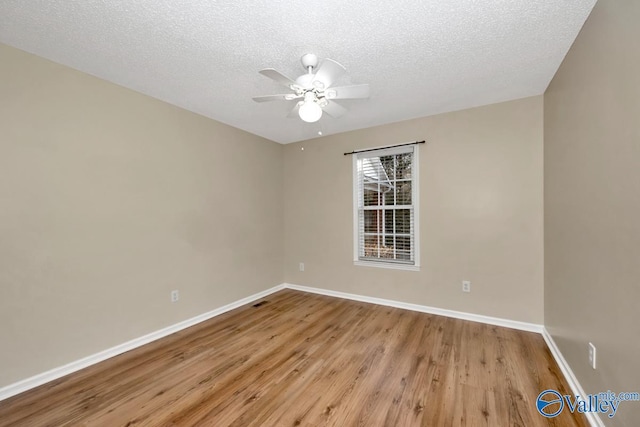 empty room featuring ceiling fan, light hardwood / wood-style flooring, and a textured ceiling