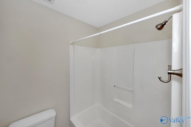 bathroom featuring a textured ceiling and toilet