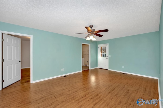 spare room with hardwood / wood-style floors, a textured ceiling, and ceiling fan