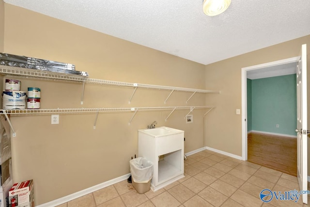 washroom featuring tile patterned floors, washer hookup, and a textured ceiling