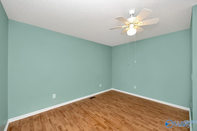 spare room featuring ceiling fan, hardwood / wood-style flooring, and a textured ceiling