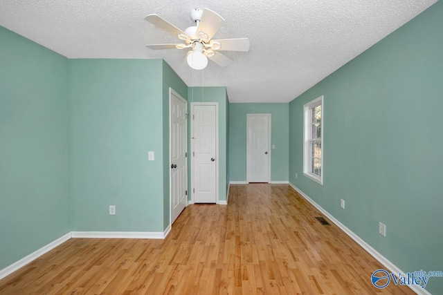 unfurnished room with ceiling fan, light hardwood / wood-style floors, and a textured ceiling