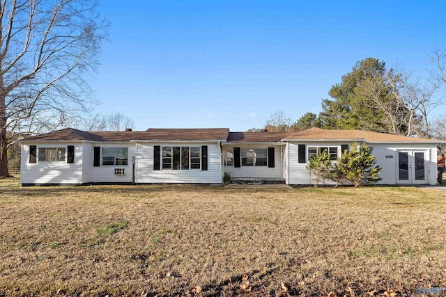 back of property with a yard and french doors