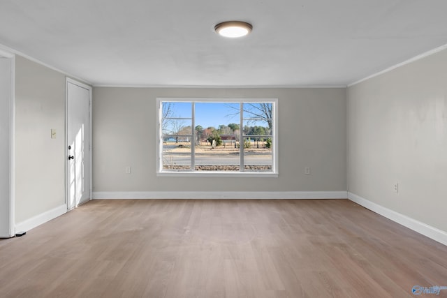 unfurnished living room with light wood-type flooring, baseboards, and crown molding