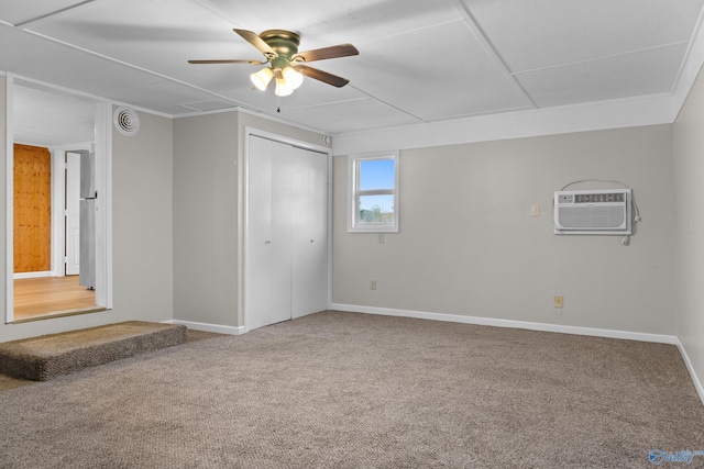 interior space with a ceiling fan, a wall unit AC, a closet, carpet flooring, and baseboards