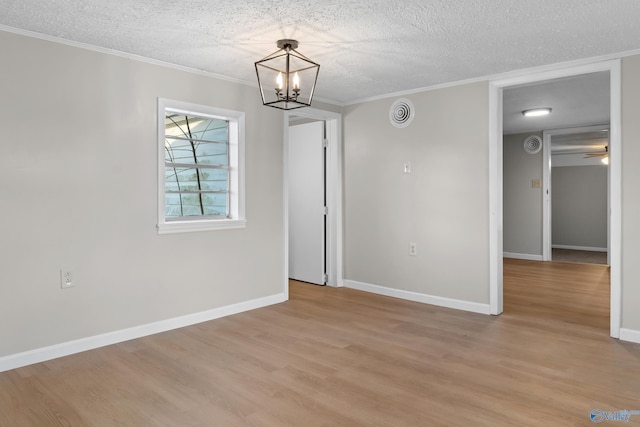 interior space featuring baseboards, a textured ceiling, crown molding, ceiling fan with notable chandelier, and light wood-type flooring