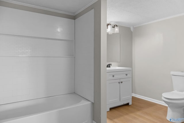 bathroom with vanity, wood finished floors, a textured ceiling, crown molding, and toilet