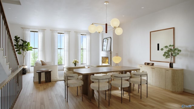 dining area with light hardwood / wood-style floors and a notable chandelier