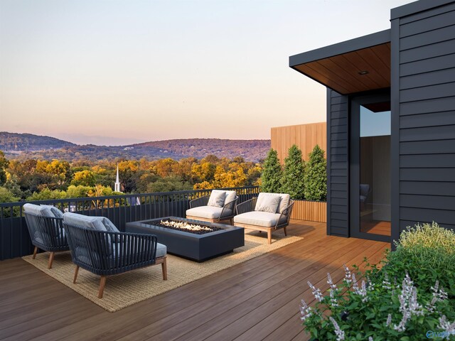 deck at dusk featuring a mountain view and an outdoor fire pit