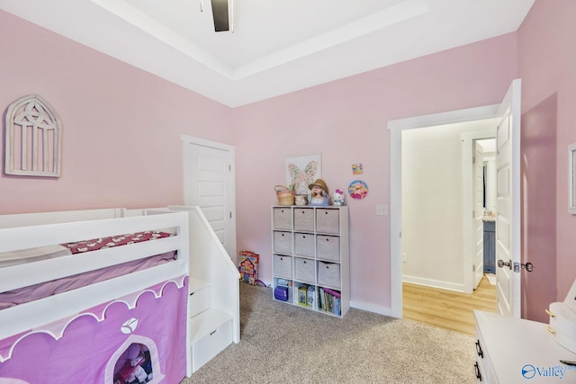 bedroom with light carpet, baseboards, a tray ceiling, and ceiling fan