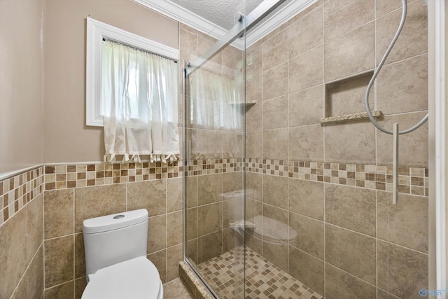 16712 Brooks Dr, Athens, AL 35611 - full bathroom featuring toilet, a stall shower, tile walls, a textured ceiling, and ornamental molding