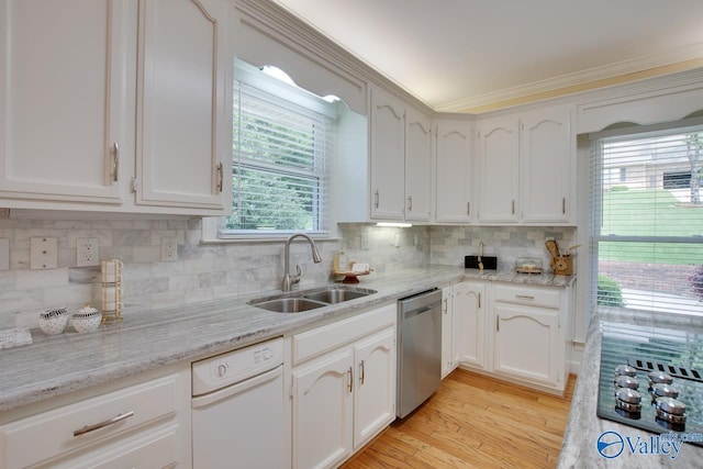 kitchen with dishwasher, a sink, black electric stovetop, white cabinetry, and backsplash