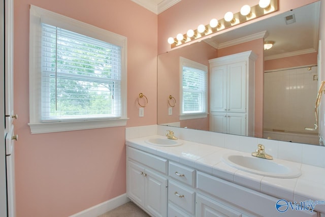 bathroom featuring double vanity, a shower, ornamental molding, and baseboards