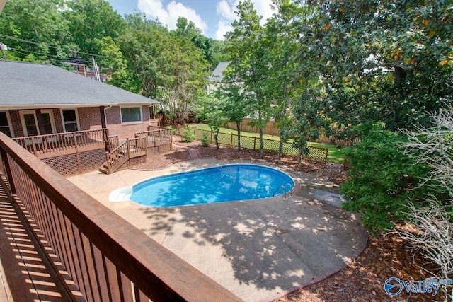 view of pool with a fenced backyard, a deck, and a patio area