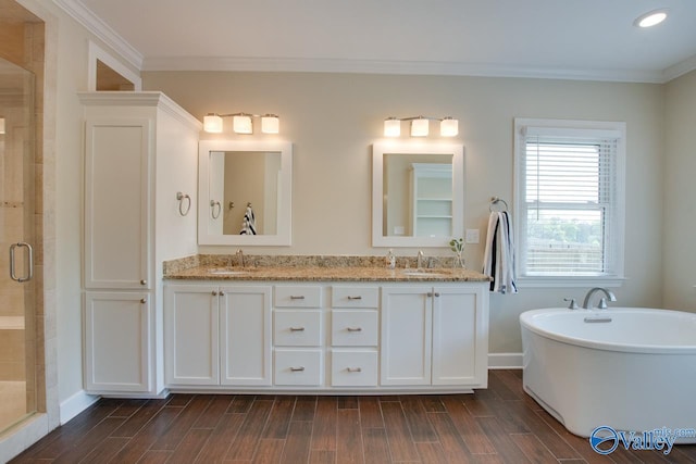 full bath with a stall shower, wood finished floors, ornamental molding, baseboards, and a soaking tub