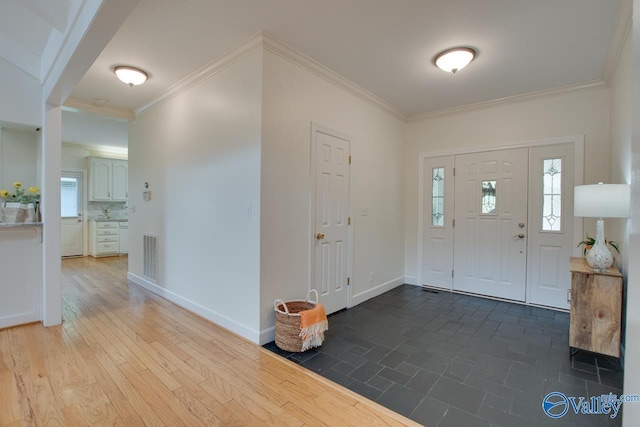 entrance foyer featuring ornamental molding and baseboards