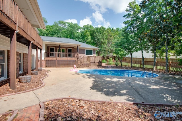 view of swimming pool with a patio, a wooden deck, fence, and stairs
