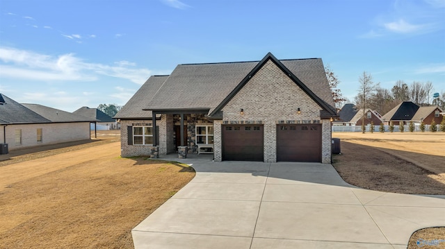 view of front of property featuring a garage, brick siding, and roof with shingles