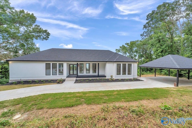 view of front facade featuring covered porch, driveway, a carport, and a front yard