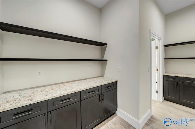 bar featuring light wood-style floors and baseboards