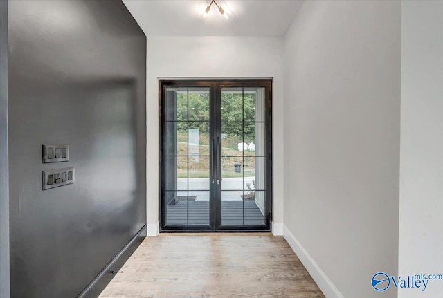 doorway to outside featuring light wood-style floors and baseboards