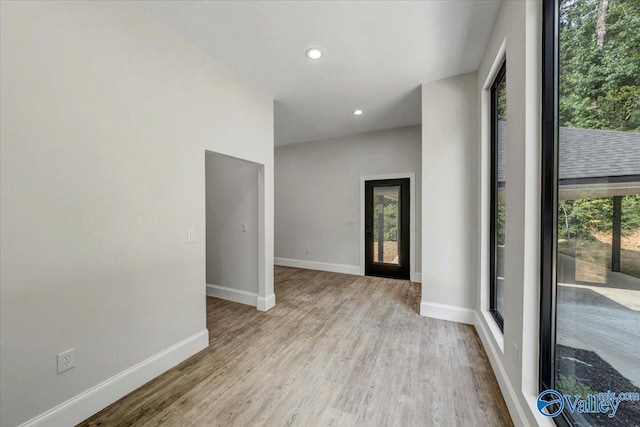 unfurnished room with light wood finished floors, recessed lighting, and baseboards