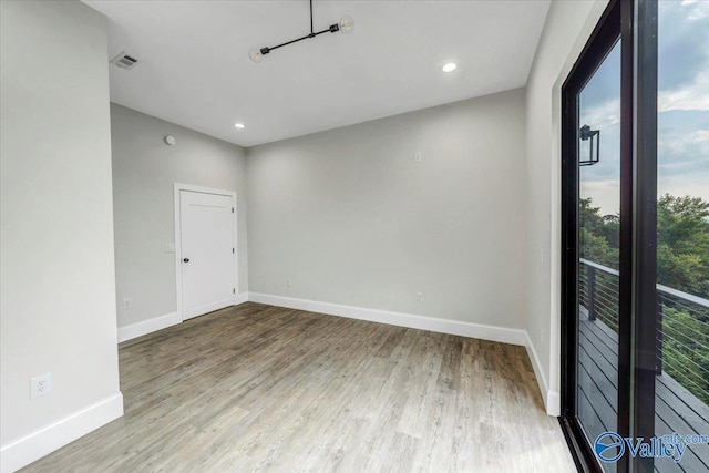 unfurnished room featuring recessed lighting, wood finished floors, visible vents, and baseboards