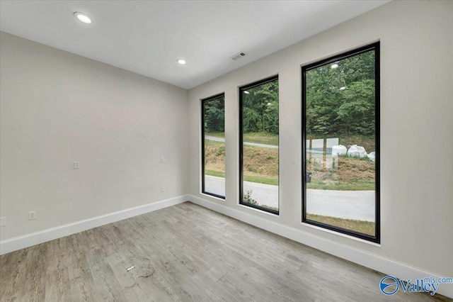 spare room featuring recessed lighting, light wood-style flooring, and baseboards