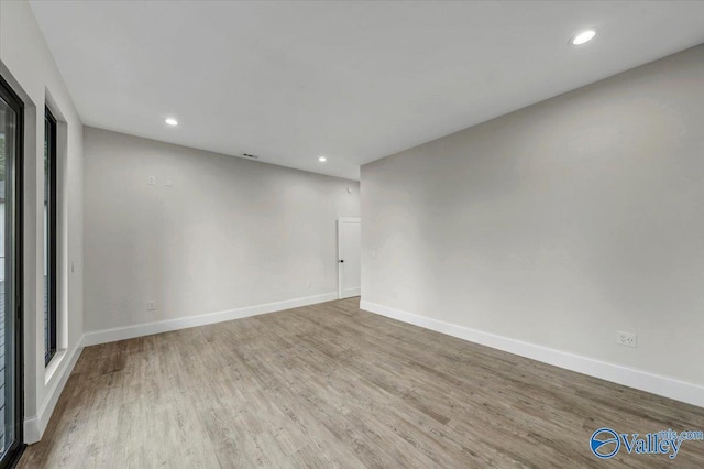 spare room featuring light wood-style flooring, baseboards, and recessed lighting