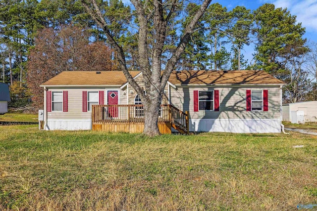 view of front of home with a front yard and a wooden deck