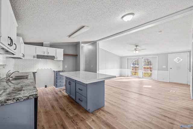 kitchen with white cabinetry, light hardwood / wood-style floors, and a textured ceiling