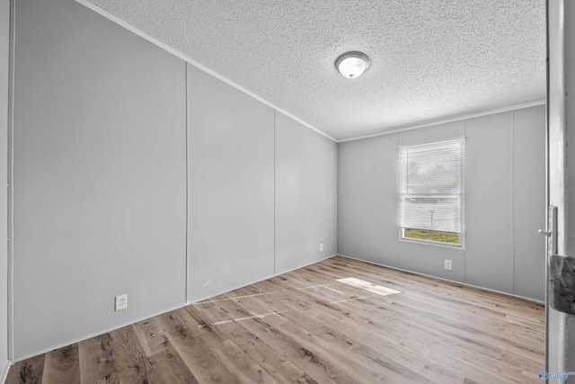 unfurnished room featuring crown molding, a textured ceiling, and light wood-type flooring