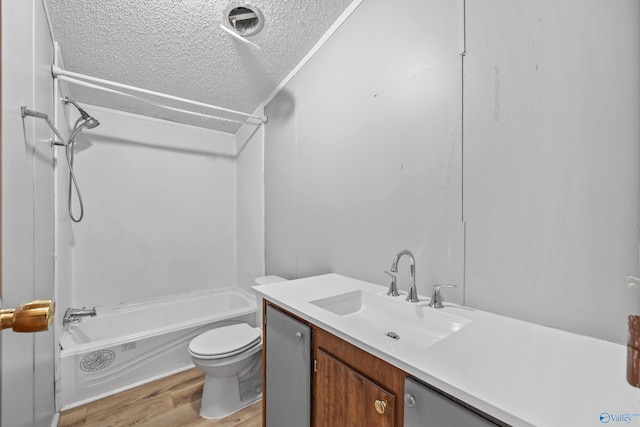 full bathroom with vanity, bathtub / shower combination, toilet, a textured ceiling, and wood-type flooring