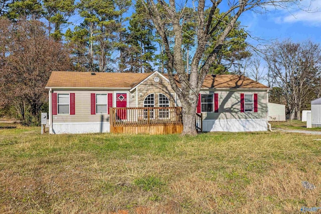 view of front of house with a deck and a front lawn