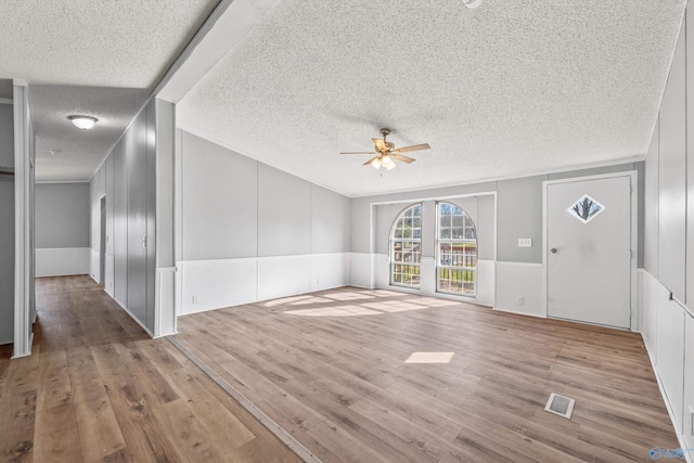 interior space featuring wood-type flooring, a textured ceiling, and ceiling fan